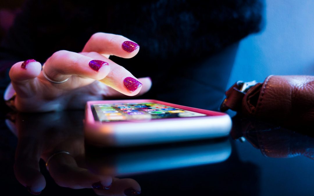 person using black smartphone with gray and pink case