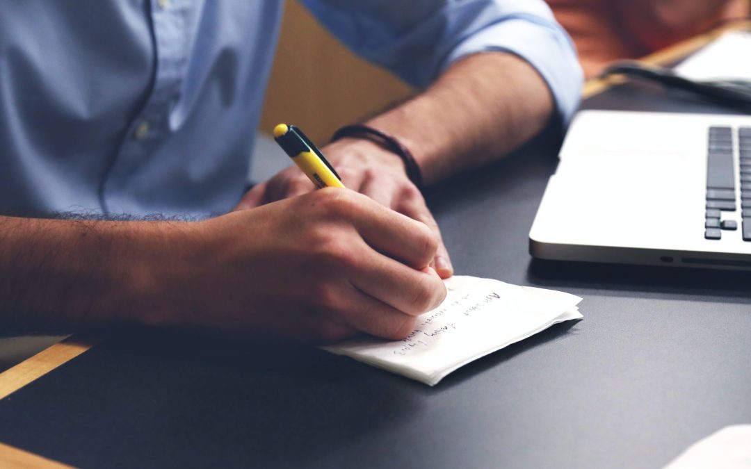 Free Person Writing on Paper Using Yellow and Black Pen Stock Photo