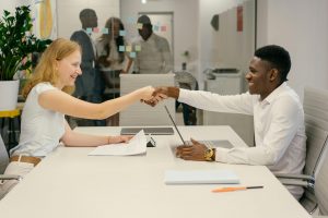 Free Business professionals completing a successful deal with a handshake in a modern office setting. Stock Photo